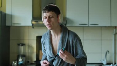 Bornozlu bir adam kepçeyle gitarist gibi davranır, müziğin ritmini ve neşesini hisseder..