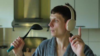 Gri bornozlu, kulaklıklı, en sevdiği şarkının tadını çıkaran, kendini hayranlarının önünde hayal eden bir adam. Genç adam mutfak gereçlerini mikrofon olarak kullanıp şarkı söylüyor..