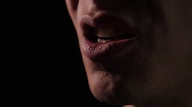 Erkek yüzü bağırıyor ya da sinirli surat ifadesi takınıyor. Öfkeli adam bağırıyor ve bağırıyor. Karanlıkta öfke ve stres hissediyor. Dişleri ve ham duyguları açığa çıkarıyor.