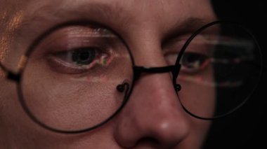 Gözlüklü tüccar dizüstü bilgisayarda çalışıyor. Borsa grafikleri ve Bitcoin BTC veya Ethereum ETH veri analizi yansıması olan bir ekran. Komisyoncu çevrimiçi. Altcoins şifreleme para ticareti