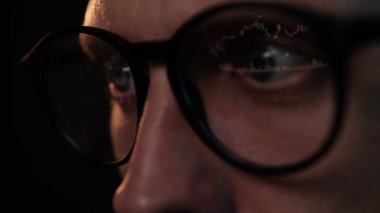 Gözlüklü tüccar dizüstü bilgisayarda çalışıyor. Borsa grafikleri ve Bitcoin BTC veya Ethereum ETH veri analizi yansıması olan bir ekran. Komisyoncu çevrimiçi. Altcoins şifreleme para ticareti