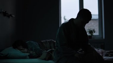 İlişki krizi. Ağlayan kadın. Aile içinde skandal ve kriz. Aile içi şiddet, taciz. Sorunlu bir adam başını eğip elleriyle yüzünü kapatıyor ve üzüntüden ağlıyor..