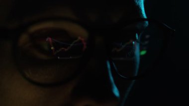 Kripto Tüccarı Bilgisayar Ekranında İzlerken Çevrimiçi Borsa Ticareti Veri Grafiği Çizelgesini Gözlük Yüzeyi Yansıması ile analiz ederken, kopyalama alanı ile kapatın. Asgari siyah arkaplan.