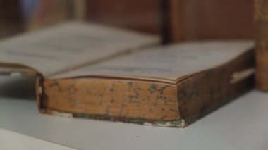 Beyaz masa yüzeyinde mermer kenarlı klasik açık kitap yakın plan.