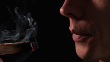 Parlayan bir Palo Santo çubuğu kutsal duman yayar. Bir erkek üzerine üflediğinde, ayin, rahatlama ve ruhsal enerji temizliğini sembolize eder.