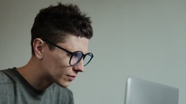 Dijital göz yorgunluğu. Yorgun genç adamın yakın plan fotoğrafı. Gözlüklerini çıkarıyor. Kuru ve asabi gözlere masaj yapıyor. Evde bilgisayar kullandıktan sonra çok çalışan adam göz yorgunluğu çekiyor..