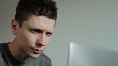 Dizüstü bilgisayarda çalışırken gözlerini ovuşturan bir adam. Uzun ekran zamanından yorgun gözler. Serbest çalışan göz kırpan ve masaj yapan biri. Laptop 'ta uzun saatler çalışmaktan görme sorunları