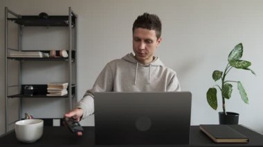 Ciddi bir adam ofis masasında oturuyor, işi başından aşkın, bilgisayarda internette akıllı telefonlarda geziniyor, cevap yazıyor, mesajlaşıyor. Odaklanma kaybı. Sosyal medyayı kontrol eder.