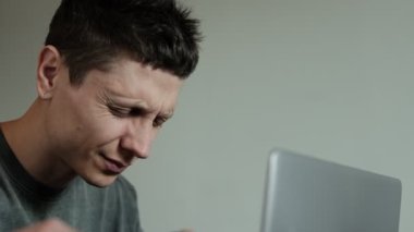 Bilgisayarın başında otururken gözlerini ovuşturan yorgun adamın yakın çekimi, uzun ekran zamanından kalma dijital göz yorgunluğu ya da yorgunluk gösteriyor