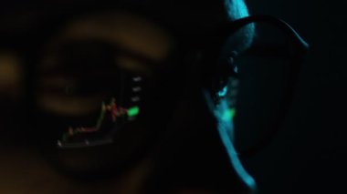 Kripto Tüccarı Bilgisayar Ekranında İzlerken Çevrimiçi Borsa Ticareti Veri Grafiği Çizelgesini Gözlük Yüzeyi Yansıması ile analiz ederken, kopyalama alanı ile kapatın. Asgari siyah arkaplan.
