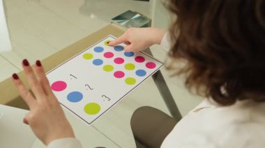 Kadın beyin aktivitesi ve koordinasyonunu canlandırmak için renkli dairelerle nörojimnastik egzersizi yapıyor.