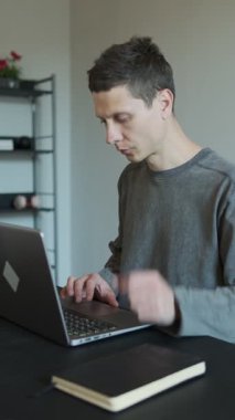 Dizüstü bilgisayarda çalışırken boynu ağrıyan bir adam. Rahatsiz çalisma pozisyonu boyun incinmesine neden oluyor. Zavallı ergonomik yüzünden kronik ağrı. Evde boyun rahatsızlığı çeken serbest çalışan biri. Dikey video