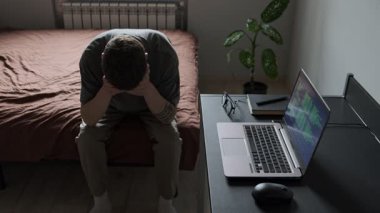 İç işlerinde umutsuzluk içinde, dizüstü bilgisayar ve gözlüklerin yanında oturan bunalımlı bir adam zihinsel yorgunluğu gösteriyor. Serbest çalışmanın gerçekçi tasviri.