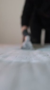 Şiltenin dezenfekte edilmesi için yatağın üzerindeki elektrikli süpürgenin hareketine yakın plan. Odadaki döşenmiş mobilyaların profesyonel temizliği.