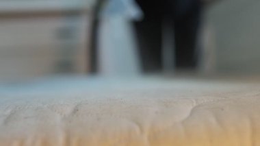 Kirli yatak yüzeyine odaklan, arka plan bulanık profesyonel temizlik olduğunu gösteriyor. Evdeki derin yatak hijyeni ve görünmez toprak temizliği kavramı.