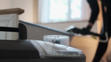 Yatak odasındaki profesyonel yatak temizliği sırasında ön planda sprey temizleme makinesi var. Modern ev temizliği. Yatak çıkarma aracıyla sterilize ediliyor