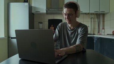 Kulaklık takan odaklanmış bir oyuncu evde yoğun bir şekilde video oyunu oynuyor, online oyun bağımlılığı kavramı