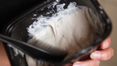 Kadın ellerinin evdeki bir konteynıra saç boyası karıştırdığı yakın plan.