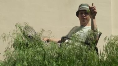 Bahçe bakımı konsepti. Adam özel mülkte uzun otları teftiş eder.