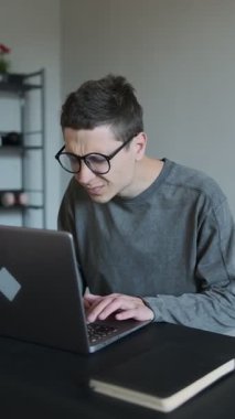 Dizüstü bilgisayarda çalışırken gözlerini ovuşturan bir adam. Uzun ekran zamanından yorgun gözler. Serbest çalışan göz kırpan ve masaj yapan biri. Laptop 'ta uzun saatler çalışmaktan görme sorunları