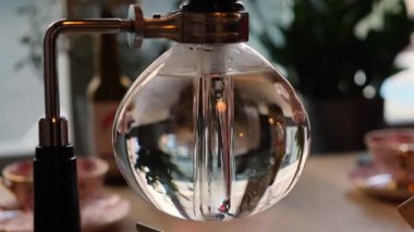 Modern çay demleme cihazı Çin Pu-erh çayı yapıyor. Kaynar suyla cam sifon çaydanlığı yakın plan.