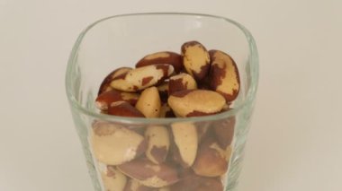 Açık fındıklı Brezilya fındığı dolu cam bardak. Sağlıklı vejetaryen atıştırmalığı ve doğal selenyum, protein ve yağ kaynağı. Organik gıda yakın çekim.