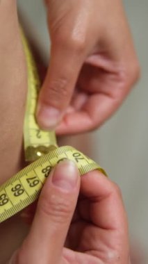 Bel ölçülerinde, iç çamaşırlı bir kadın. Formda kalma sürecinin yakın plan görüntüsü, yüzü yok, gerçekçi vücut sahnesi