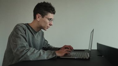 Bilgisayarın başında otururken gözlerini ovuşturan yorgun adamın yakın çekimi, uzun ekran zamanından kalma dijital göz yorgunluğu ya da yorgunluk gösteriyor