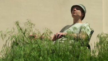 Bahçe bakımı konsepti. Adam özel mülkte uzun otları teftiş eder.