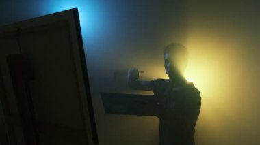 Duygusal genç ressam, karamsar sinemada fırça darbeleriyle tuvale resim yapıyor. Yaratıcı süreç.