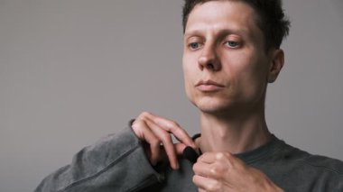 Adamın kıyafetlerine lavalier mikrofon taktığına yakın çekim. Bir podcast veya vlog için bir röportaj kaydetmeye hazırlanılıyor