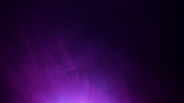 Siyah arka planda yavaş çekim renkli neon dumanı, yavaşça dönüyor. Yaratıcı görseller, meditasyon veya müzik için modern soyut tasarım. Gradyan renkleri mavi ve mor.