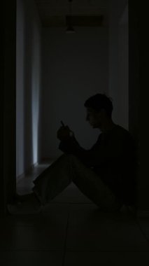Karanlık bir odada tek başına oturan genç bir adam telefonuna bakıyor ve üzüntülü eski kız arkadaşını hatırlıyor..