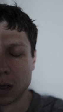 Ayrılık ya da kayıpla ilgili kötü haberler duyduktan sonra tek başına oturup yüzünü kapatıp ağlayan genç bir adam..