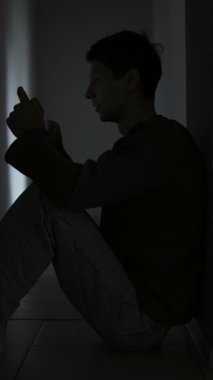 Karanlık bir odada tek başına oturan genç bir adam telefonuna bakıyor ve üzüntülü eski kız arkadaşını hatırlıyor..