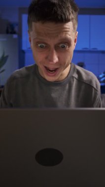 Adam kötü haberi dizüstü bilgisayardan alır, hayal kırıklığıyla, günlük kıyafetlerle, evdeki kanepede oturarak, gerçek hayatta, gerçek hayatta,.