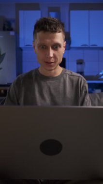 Adam kötü haberi dizüstü bilgisayardan alır, hayal kırıklığıyla, günlük kıyafetlerle, evdeki kanepede oturarak, gerçek hayatta, gerçek hayatta,.