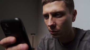 Boş suratlı akıllı telefonları kapatarak içerik bağımlılığını, sosyal medya bağımlılığını gösteriyorlar. Minimalist gri arkaplan.