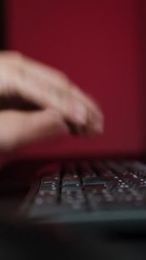 Ofisteki genç adam stresli bir şekilde klavyeye vuruyor, uzaktan kumandayla çalışıyor ve hayal kırıklığı yaşıyor..