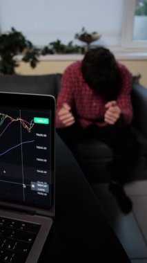 Yatırım stresinden bitap düşmüş bir adam, umutsuzluk içinde başını tutuyor, iş baskısı ve duygusal yorgunluk kavramı.