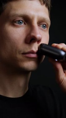 Küçük elektrikli traş makinesi, günlük tımar ve hijyen rutiniyle tıraş olan bir adamın yakın çekimi. Mükemmel yaşam tarzı konsepti videosu.