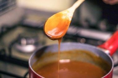 Close-up of a chef's hand-cooking creme caramel sauce 