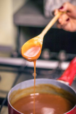 Close-up of a chef's hand-cooking creme caramel sauce 