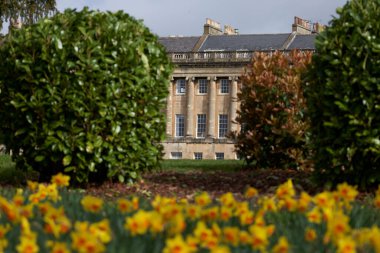 Bath, Somerset, İngiltere - 21 Mart 2023: Birleşik Krallık 'ın Somerset kentindeki UNESCO Dünya Mirası kentindeki tarihi Royal Crescent önünde bahar çiçekleri