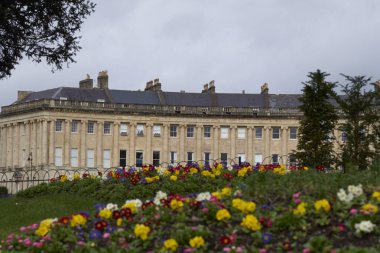 Bath, Somerset, İngiltere - 21 Mart 2023: Birleşik Krallık 'ın Somerset kentindeki UNESCO Dünya Mirası kentindeki tarihi Royal Crescent önünde bahar çiçekleri