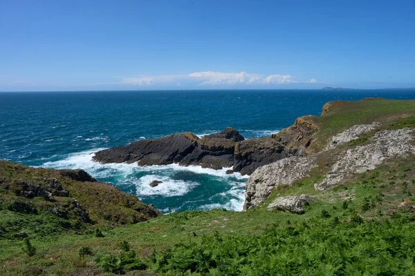 Galler 'deki Pembrokeshire açıklarındaki Skomer Adası' nın engebeli kıyı şeridi..