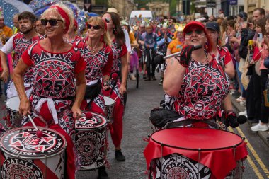 Bath, İngiltere, Birleşik Krallık - 8 Temmuz 2023: Somerset 'teki tarihi Bath kentinin caddelerinde ilerleyen geleneksel karnavalda süslü kostümlerle müzik ve dans grubu geçit töreni.