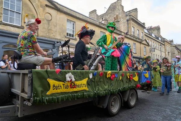 イギリス イングランド 2023年7月8日 サマセットのバスの歴史的な街を進むにつれて 毎年恒例のカーニバルで行われる華やかな衣装で音楽とダンスのグループパレード — ストック写真