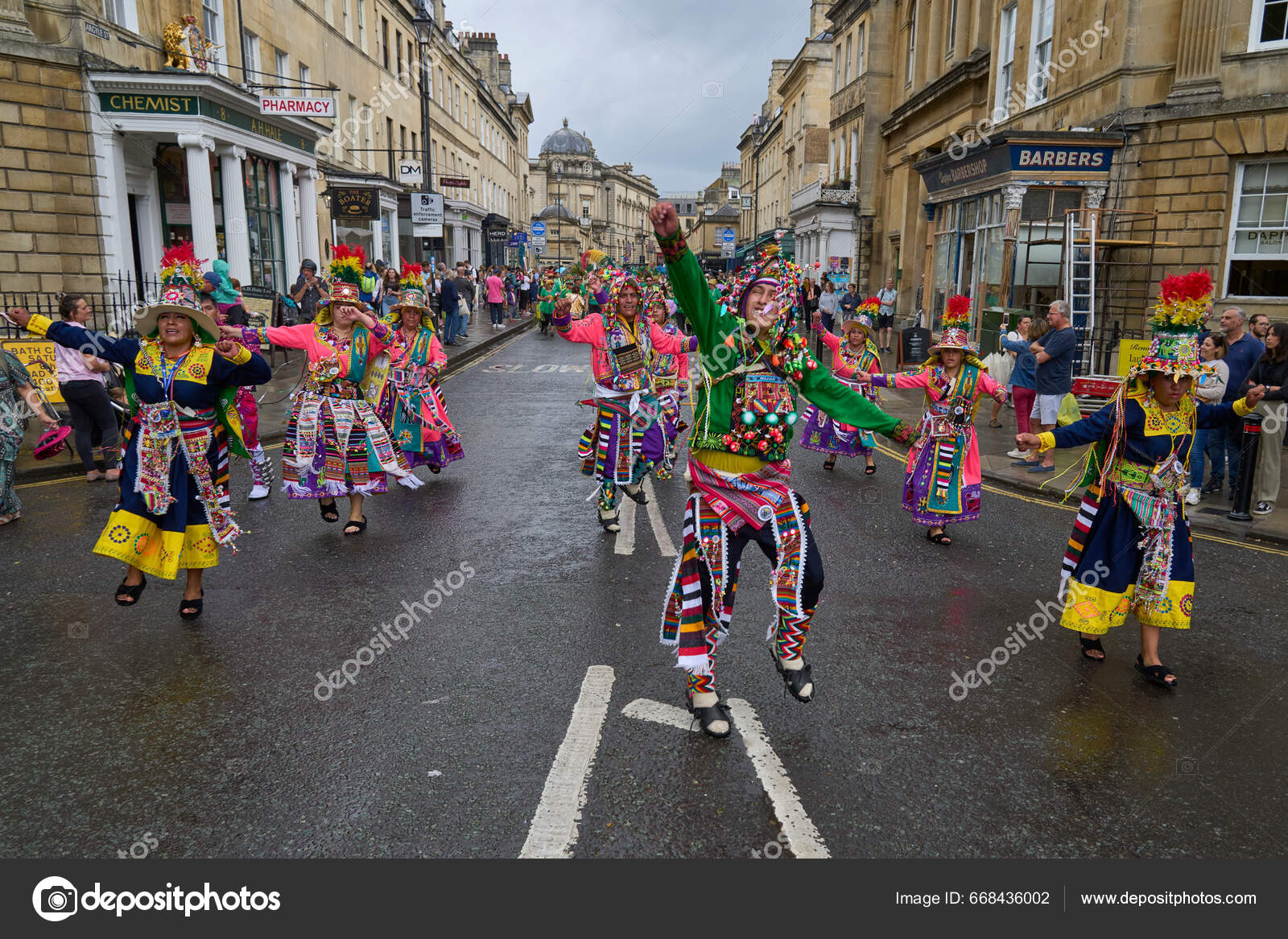 Dancers and musicians dressed in ornate costumes parade through