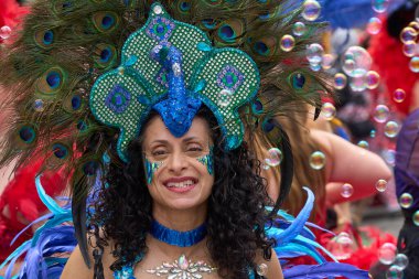 Bath, İngiltere, Birleşik Krallık - 13 Temmuz 2024: Somerset 'teki tarihi Bath kentinin caddelerinde ilerleyen geleneksel karnavalda süslü kostümlü dansçılar.